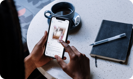 Personne consultant la rubrique « Pour toi » Tiktok sur smartphone dans un café avec tasse et carnet